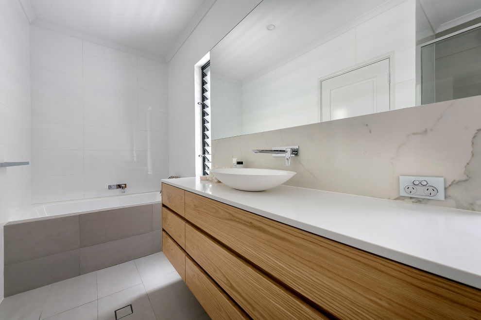 Large scandi ensuite bathroom in Perth with flat-panel cabinets, light wood cabinets, a walk-in shower, a one-piece toilet, white tiles, marble tiles, white walls, porcelain flooring, a vessel sink, engineered stone worktops, grey floors, an open shower, white worktops, double sinks and a floating vanity unit.