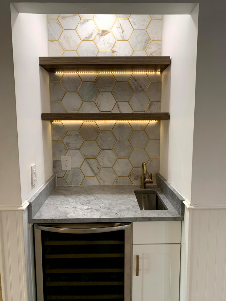 Inspiration for a small modern single-wall porcelain tile and brown floor wet bar remodel in Miami with an undermount sink, shaker cabinets, white cabinets, marble countertops, white backsplash, marble backsplash and gray countertops