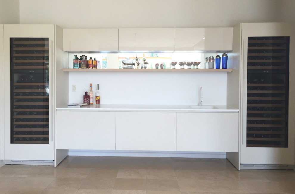 Large contemporary single-wall wet bar in Other with an integrated sink, flat-panel cabinets, marble benchtops, white splashback, stone slab splashback, ceramic floors and white cabinets.