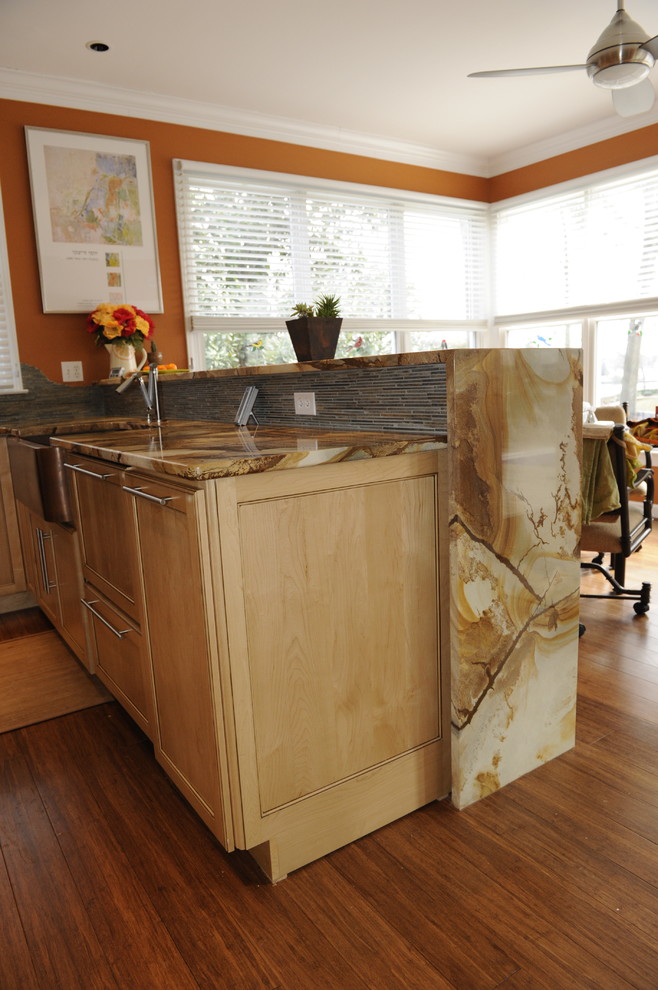 Eat-in kitchen - mid-sized transitional u-shaped light wood floor eat-in kitchen idea in Baltimore with a farmhouse sink, light wood cabinets, onyx countertops, stainless steel appliances, an island and beaded inset cabinets