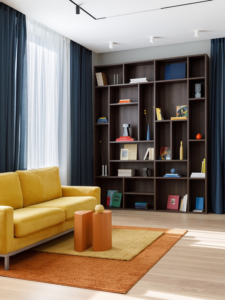 Стильный дизайн: большая гостиная комната в современном стиле с с книжными шкафами и полками, светлым паркетным полом, желтым полом и горчичным диваном - последний тренд