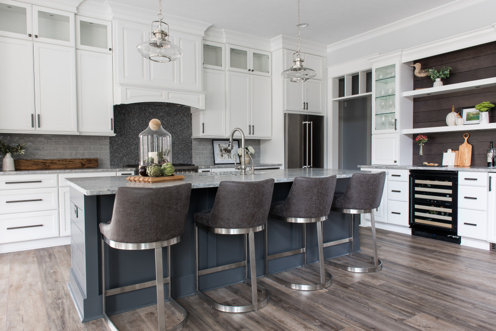 Inspiration for a mid-sized transitional l-shaped dark wood floor enclosed kitchen remodel in Indianapolis with an undermount sink, shaker cabinets, white cabinets, gray backsplash, stainless steel appliances, an island and beige countertops