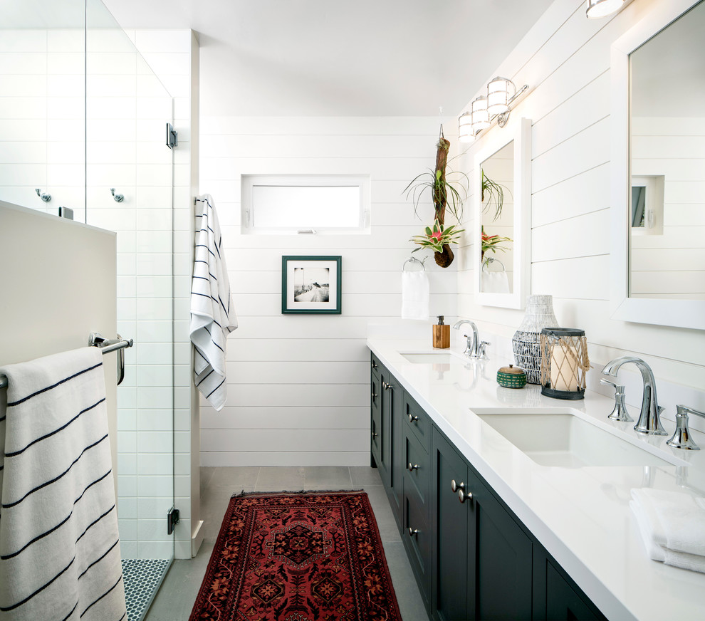 Photo of a mid-sized beach style master bathroom in San Francisco with shaker cabinets, blue cabinets, a curbless shower, a two-piece toilet, white tile, white walls, engineered quartz benchtops, grey floor, a hinged shower door, an undermount sink and white benchtops.
