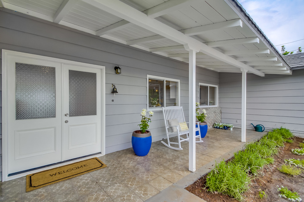 This is an example of a small front yard verandah in San Diego with tile and a roof extension.