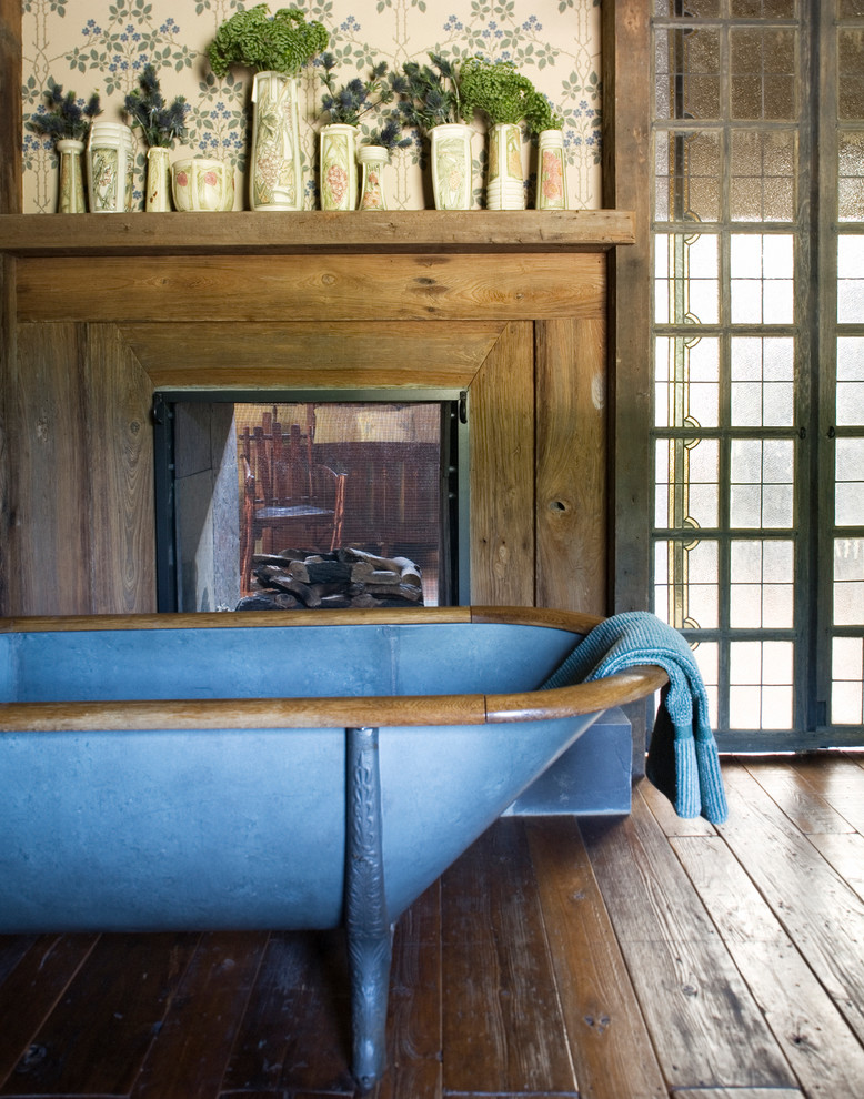 Country master bathroom in New York with a claw-foot tub and dark hardwood floors.