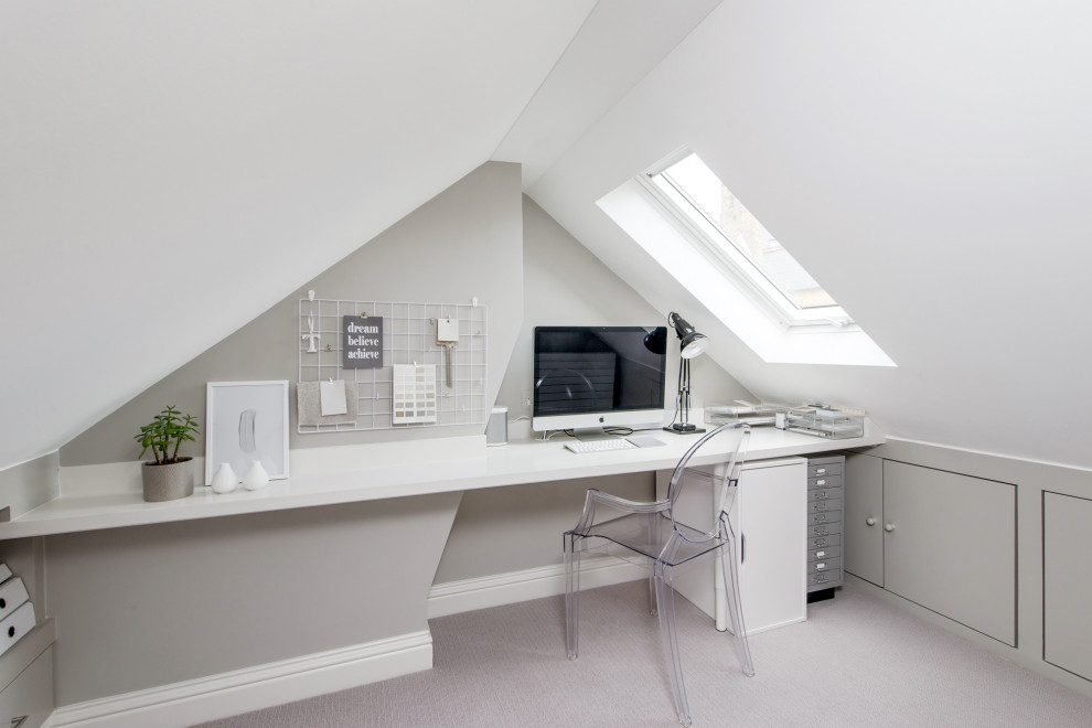 Inspiration for a mid-sized transitional study room in London with grey walls, carpet, a built-in desk and grey floor.