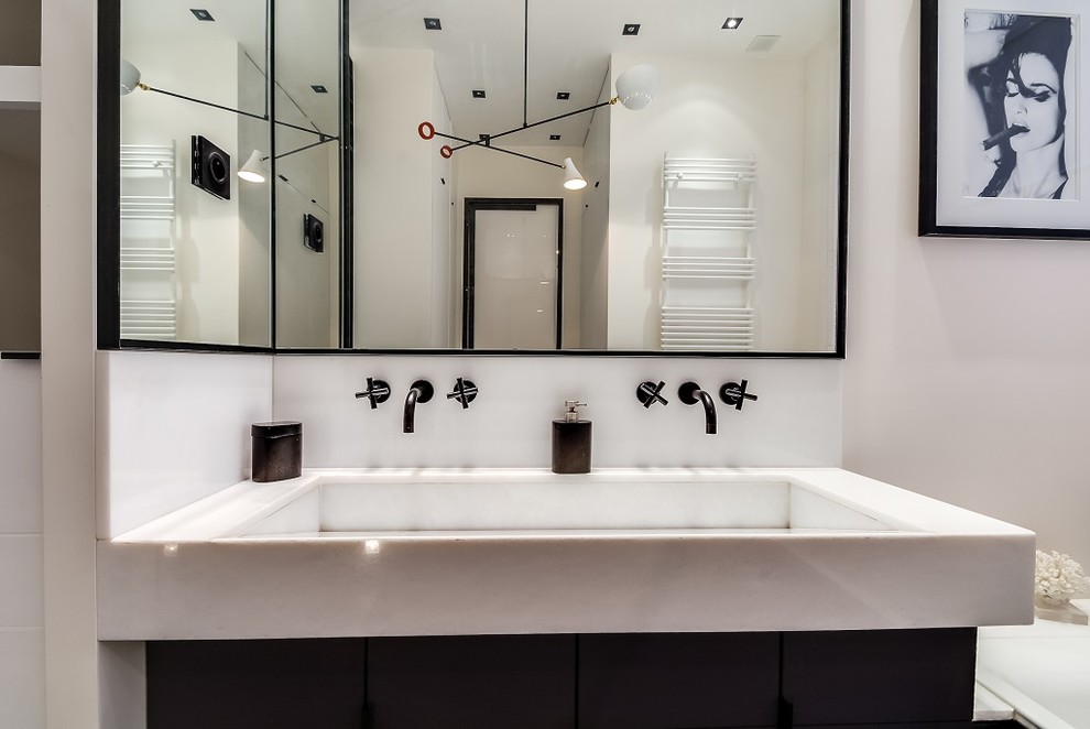 This is an example of an expansive contemporary master bathroom in Paris with marble, a curbless shower, white walls, concrete floors, grey floor, a hinged shower door, beaded inset cabinets, black cabinets, an undermount tub, white tile, a trough sink, marble benchtops and white benchtops.