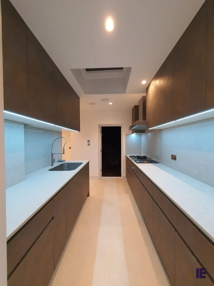 Photo of a small contemporary u-shaped enclosed kitchen in London with a single-bowl sink, quartz worktops, white splashback, white worktops and feature lighting.
