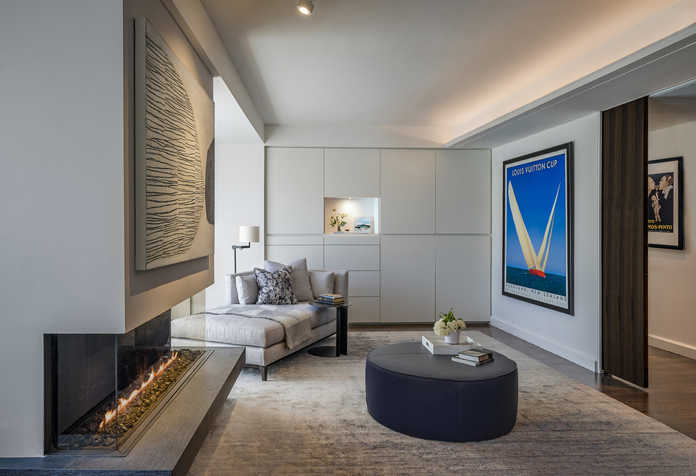 Inspiration for a modern master bedroom in Boston with grey walls, medium hardwood floors, a ribbon fireplace, a plaster fireplace surround, recessed and brown floor.