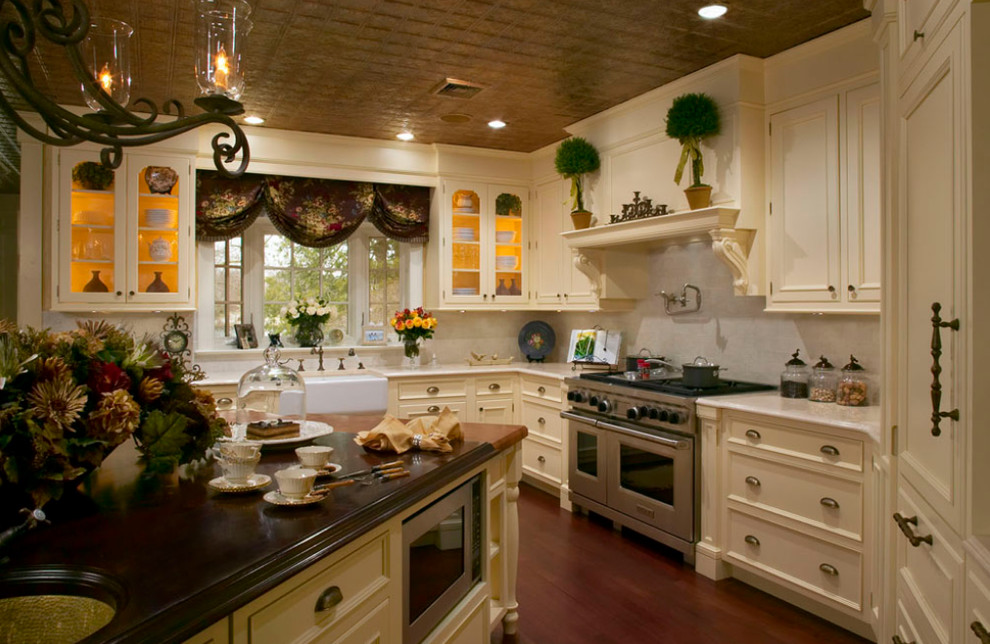 Photo of a large traditional l-shaped open plan kitchen in New York with a farmhouse sink, recessed-panel cabinets, yellow cabinets, marble benchtops, white splashback, stone tile splashback, stainless steel appliances, medium hardwood floors and with island.