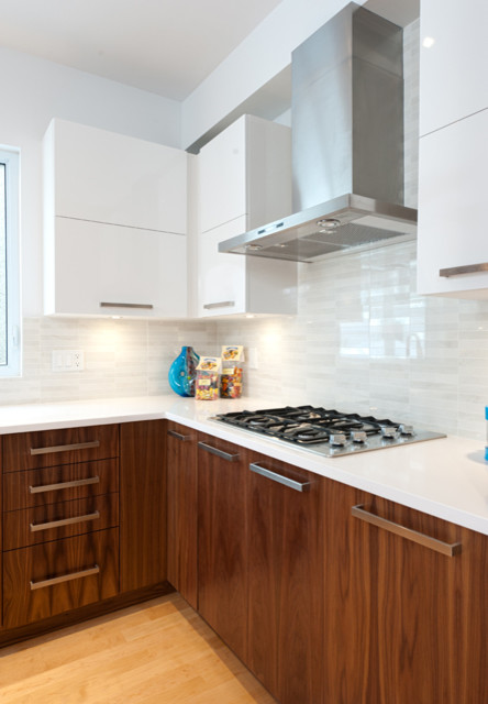 Design ideas for a large modern l-shaped eat-in kitchen in Ottawa with an undermount sink, flat-panel cabinets, white cabinets, quartz benchtops, white splashback, ceramic splashback, stainless steel appliances, light hardwood floors and with island.
