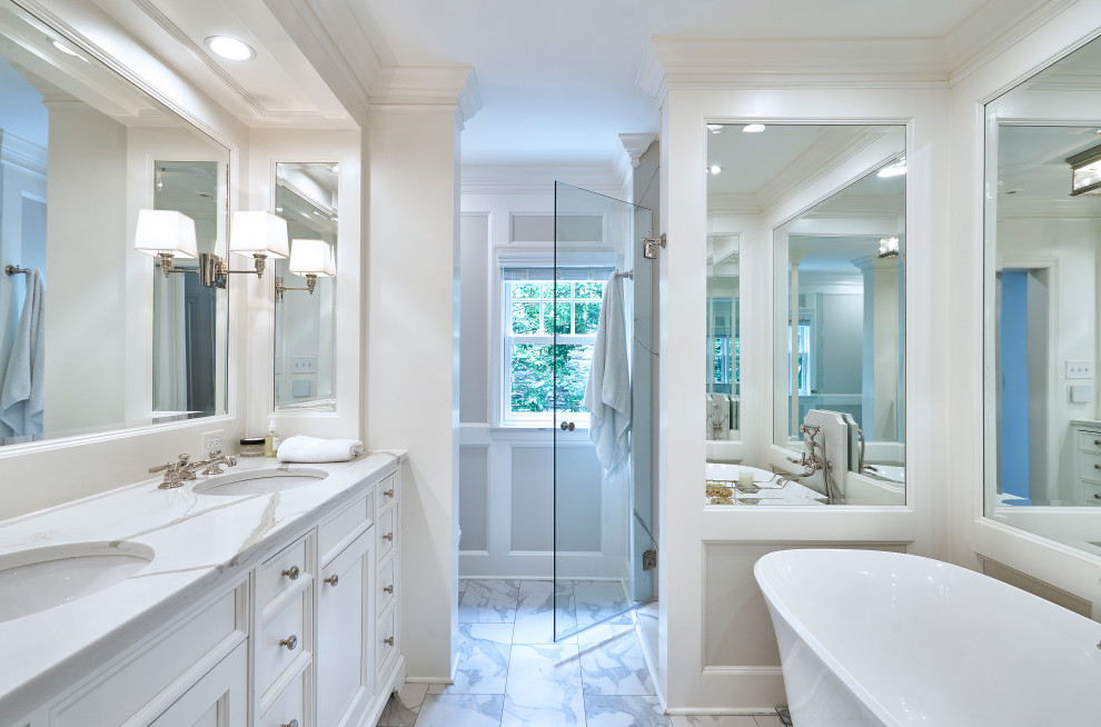 This is an example of a traditional master bathroom in Philadelphia with shaker cabinets, white cabinets, a freestanding tub, a corner shower, gray tile, marble, grey walls, marble floors, a console sink, quartzite benchtops, grey floor, a hinged shower door, white benchtops, a double vanity, a built-in vanity and panelled walls.