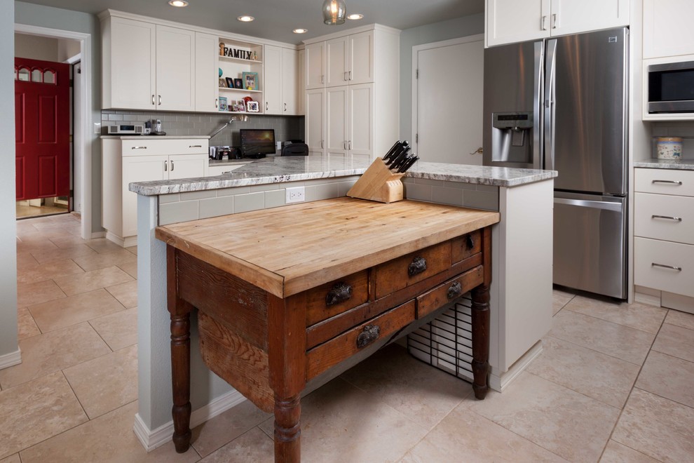 This is an example of a large eclectic l-shaped eat-in kitchen in Seattle with an undermount sink, shaker cabinets, white cabinets, quartz benchtops, grey splashback, subway tile splashback, stainless steel appliances, porcelain floors and with island.