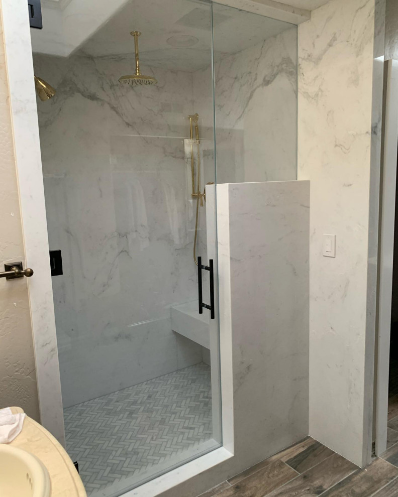 Design ideas for a mid-sized modern master bathroom in Orange County with white tile, marble, white walls, light hardwood floors, marble benchtops, a hinged shower door, white benchtops and a shower seat.