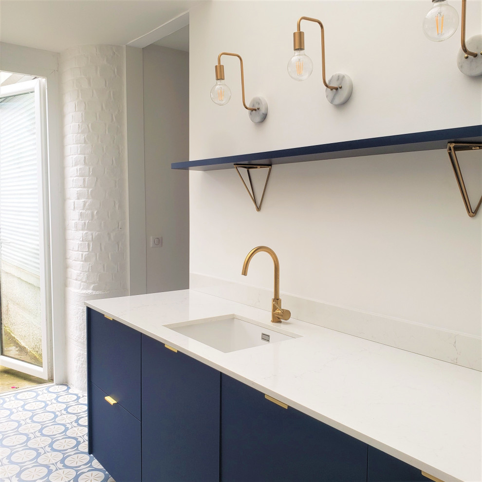 Esempio di una grande cucina parallela minimalista chiusa con lavello sottopiano, ante lisce, ante blu, top in quarzite, paraspruzzi bianco, paraspruzzi in quarzo composito, elettrodomestici da incasso, pavimento in cementine, nessuna isola, pavimento blu e top bianco