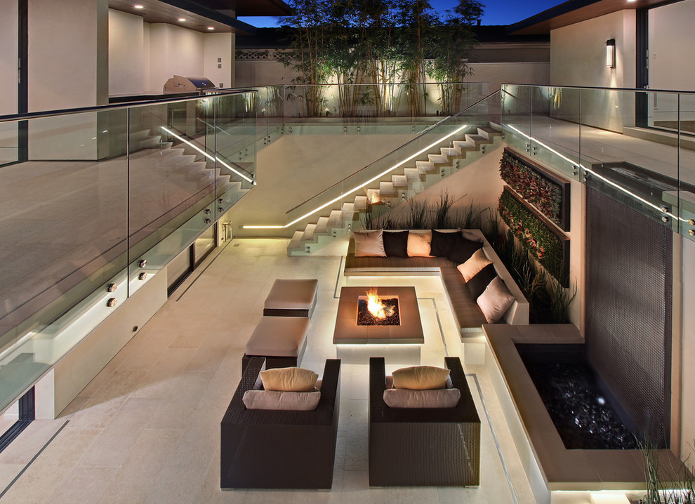 This is an example of a contemporary courtyard patio in Orange County with a fire feature.