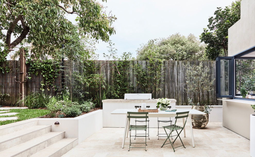 Inspiration for a large beach style backyard garden in Sydney with natural stone pavers.
