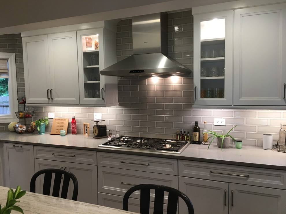 Large transitional u-shaped dark wood floor and brown floor open concept kitchen photo in Chicago with an undermount sink, flat-panel cabinets, white cabinets, quartz countertops, gray backsplash, ceramic backsplash, stainless steel appliances, an island and gray countertops