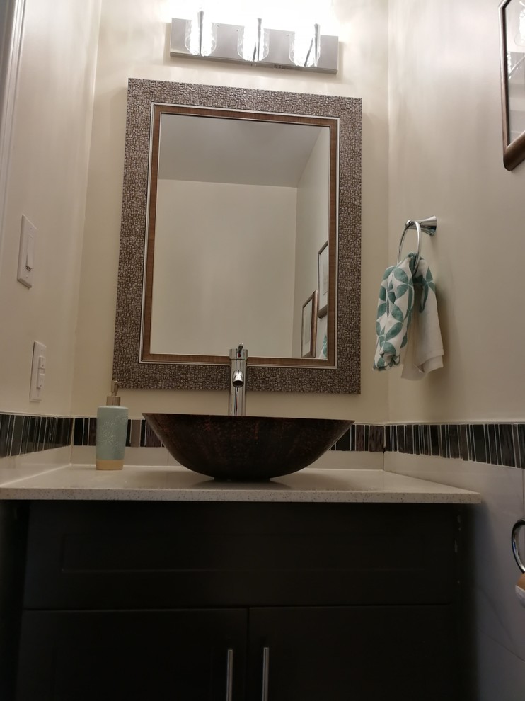 Photo of a small transitional powder room in Toronto with flat-panel cabinets, black cabinets, black tile, mosaic tile, beige walls, marble floors, a vessel sink, limestone benchtops, white floor and white benchtops.