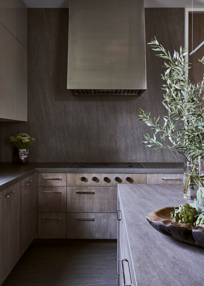 Réalisation d'une cuisine minimaliste en bois brun avec un placard à porte plane, une crédence grise, îlot, un sol gris et un plan de travail gris.