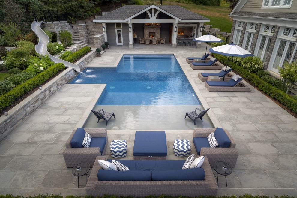 Inspiration for a large contemporary side yard rectangular lap pool in Toronto with a water slide and natural stone pavers.