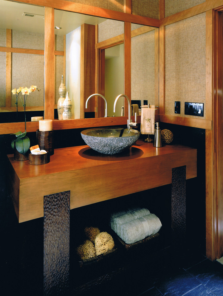 This is an example of a large asian master bathroom in San Diego with a vessel sink, wood benchtops, flat-panel cabinets, medium wood cabinets, an open shower, a one-piece toilet, ceramic tile, beige walls and ceramic floors.