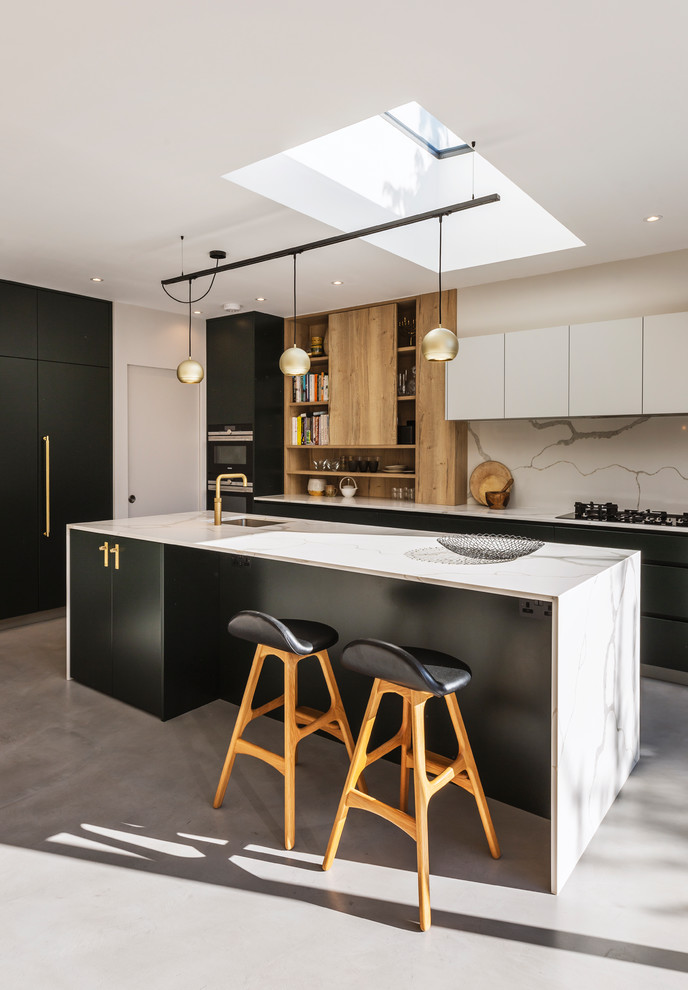 Contemporary kitchen in London with a single-bowl sink, flat-panel cabinets, white splashback, stone slab splashback, concrete floors, with island, grey floor and white benchtop.