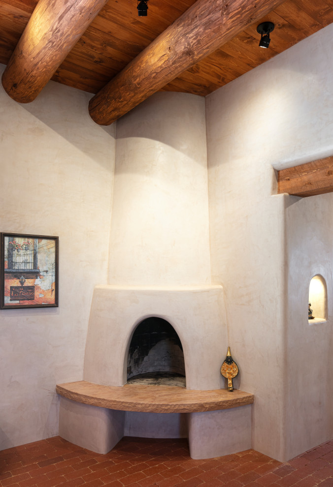 Пример оригинального дизайна: гостиная комната в стиле фьюжн с белыми стенами, кирпичным полом, угловым камином и фасадом камина из штукатурки