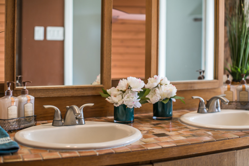 Mid-sized midcentury master bathroom in Albuquerque with flat-panel cabinets, medium wood cabinets, a corner tub, an alcove shower, a two-piece toilet, brown tile, terra-cotta tile, brown walls, ceramic floors, a drop-in sink and tile benchtops.