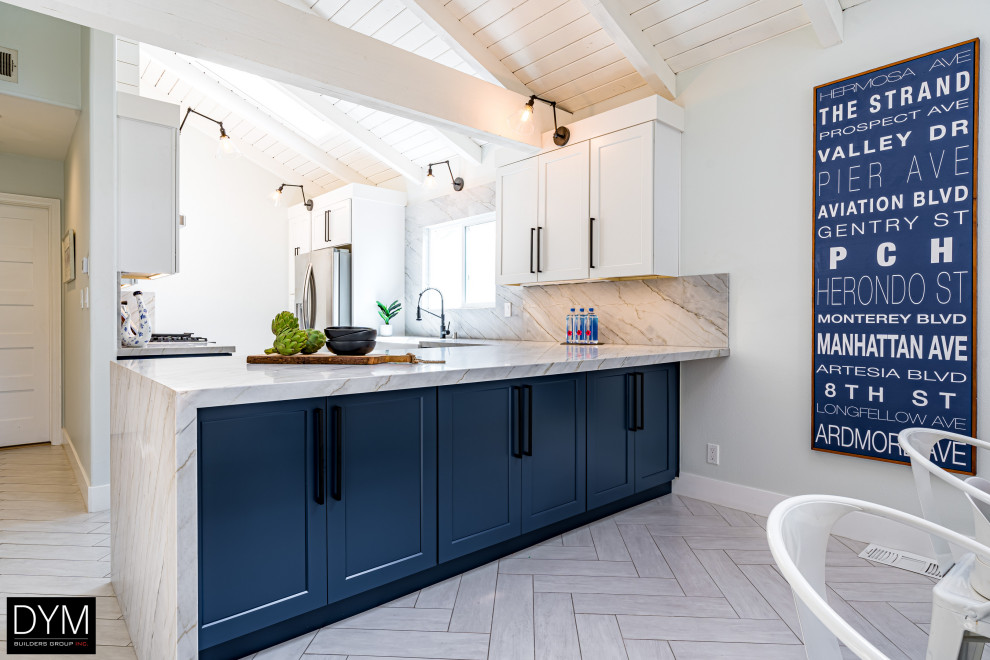 Beach style galley eat-in kitchen in Los Angeles with a farmhouse sink, shaker cabinets, blue cabinets, quartz benchtops, white splashback, engineered quartz splashback, stainless steel appliances, a peninsula, white floor, white benchtop, vaulted and light hardwood floors.