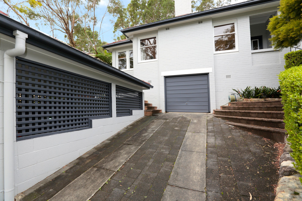 Design ideas for a mid-sized transitional two-storey brick grey exterior in Sydney with a gable roof.