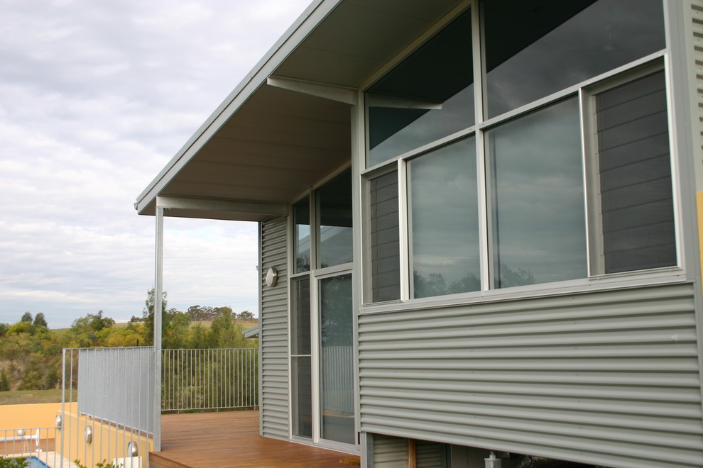 Design ideas for a mid-sized industrial backyard verandah in Sydney with decking and a roof extension.