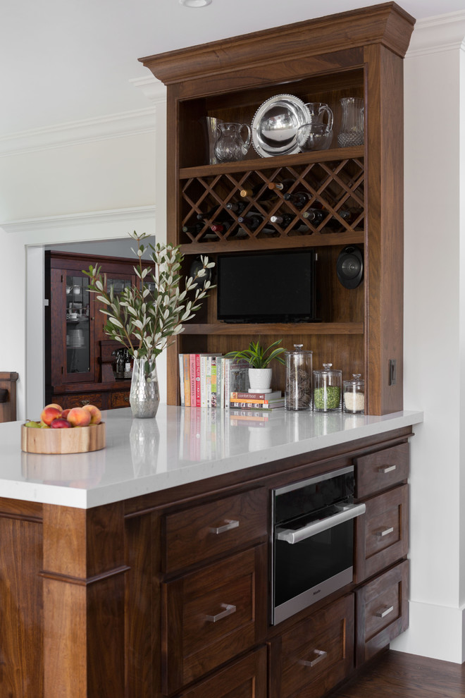 Inspiration for a large transitional l-shaped dark wood floor eat-in kitchen remodel in San Francisco with an undermount sink, shaker cabinets, gray cabinets, solid surface countertops, white backsplash, ceramic backsplash, stainless steel appliances and an island