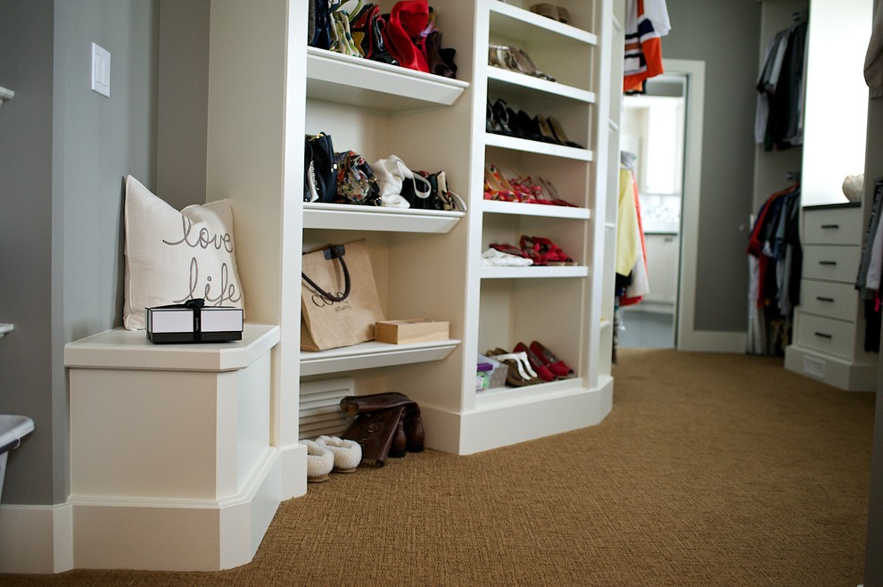 Large transitional gender-neutral dressing room in Edmonton with open cabinets, white cabinets and carpet.