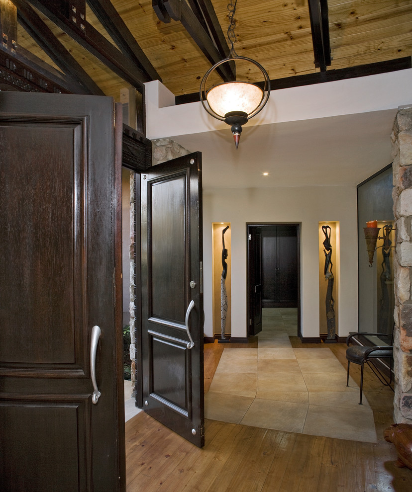 This is an example of a traditional entryway in Other with a double front door and a dark wood front door.