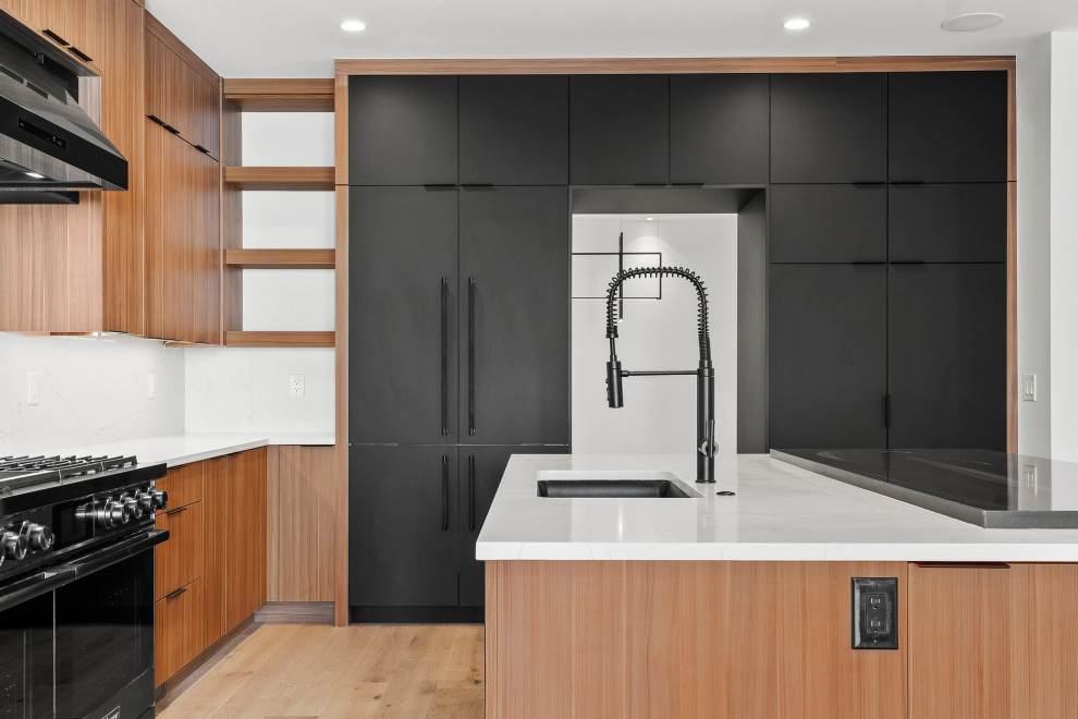 Idee per un'ampia cucina contemporanea con lavello sottopiano, ante lisce, ante nere e paraspruzzi bianco