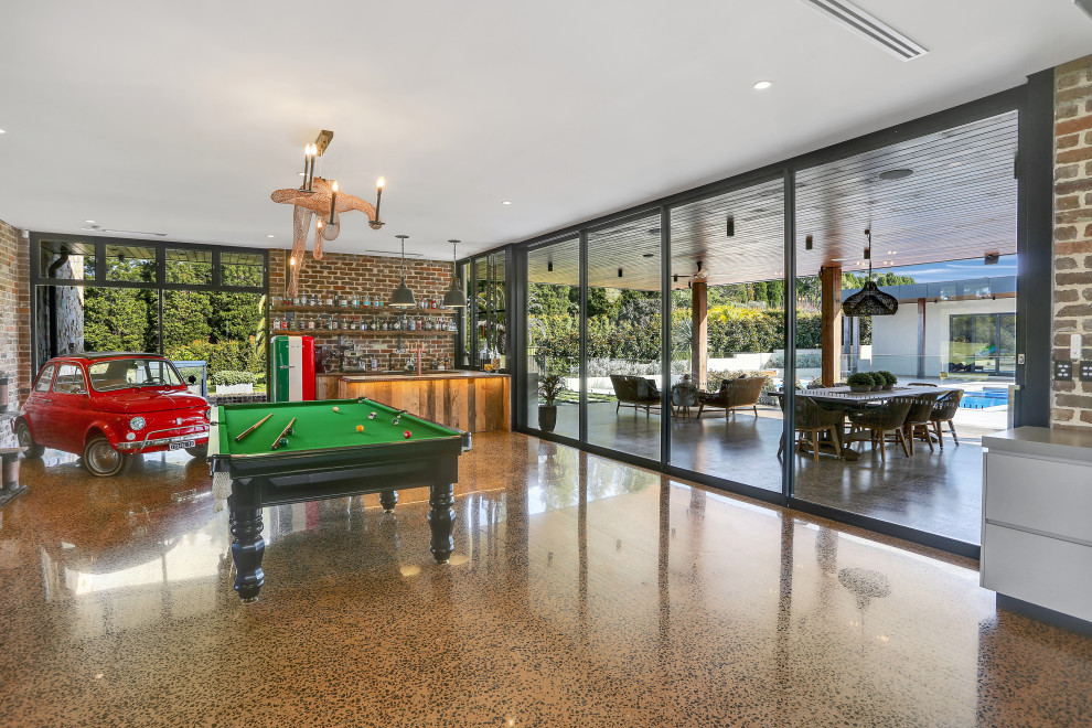 シドニーにあるラグジュアリーな巨大なコンテンポラリースタイルのおしゃれなオープンリビング (ゲームルーム、茶色い壁、コンクリートの床、茶色い床、レンガ壁) の写真