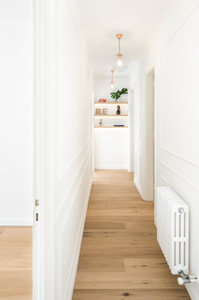 Imagen de recibidores y pasillos escandinavos de tamaño medio con paredes blancas, suelo de madera en tonos medios y suelo marrón