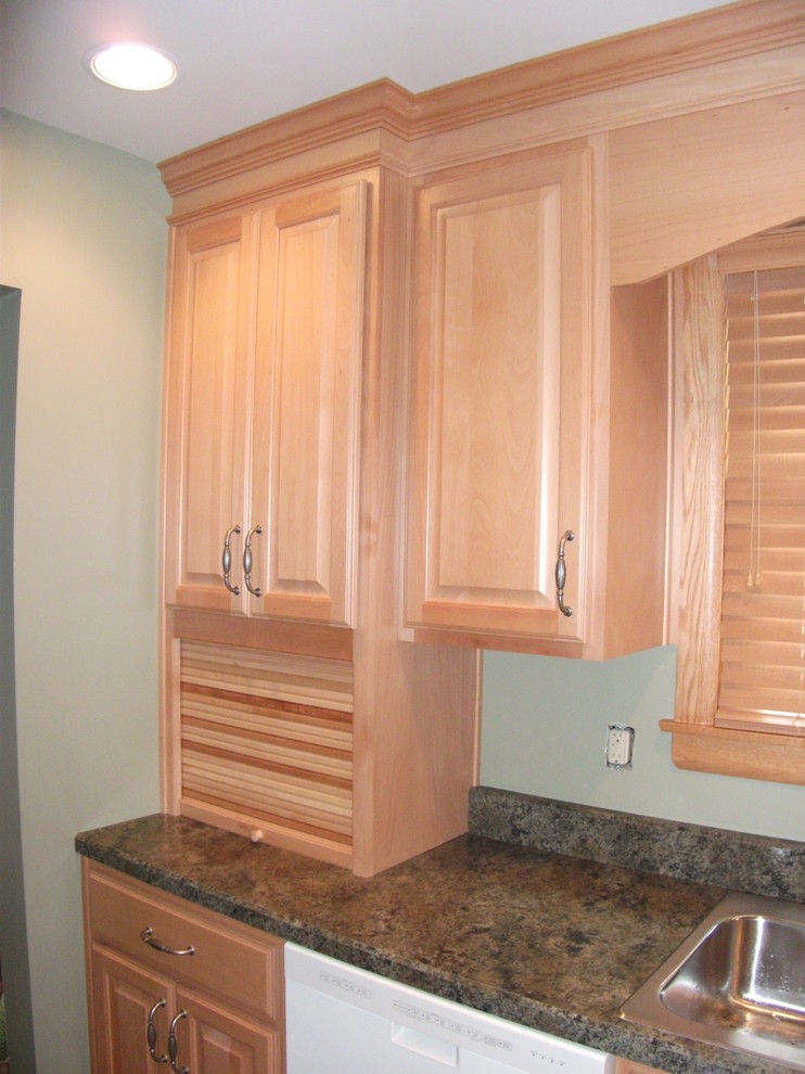 Example of a classic vinyl floor kitchen design with a drop-in sink, raised-panel cabinets, light wood cabinets, laminate countertops, green backsplash and white appliances
