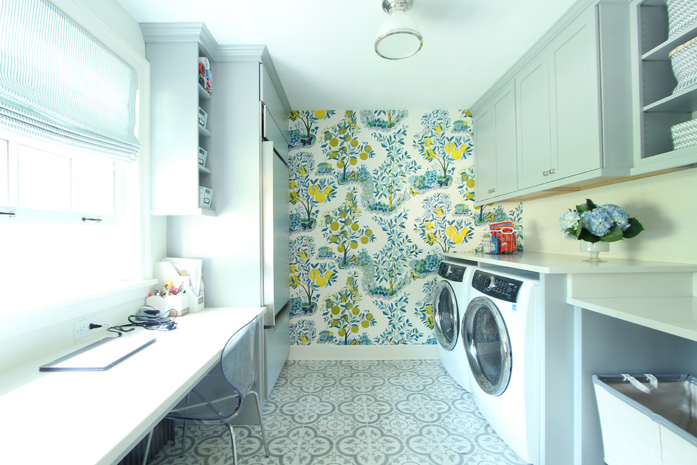 Photo of a mid-sized transitional galley dedicated laundry room in Other with an undermount sink, shaker cabinets, blue cabinets, quartz benchtops, white walls, porcelain floors, a side-by-side washer and dryer, multi-coloured floor and white benchtop.