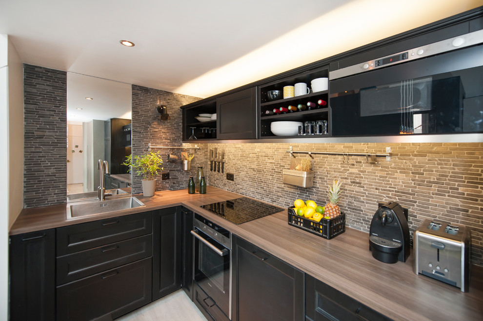 Inspiration for a mid-sized transitional l-shaped eat-in kitchen in Paris with a drop-in sink, recessed-panel cabinets, black cabinets, wood benchtops, multi-coloured splashback, matchstick tile splashback, black appliances, no island and beige benchtop.