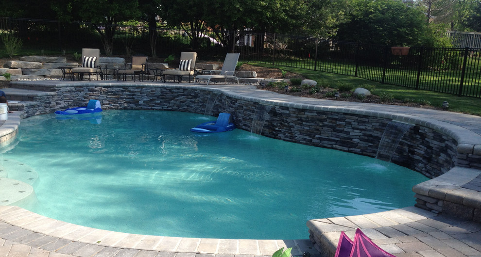 Mid-sized transitional backyard concrete paver and kidney-shaped lap hot tub photo in Detroit