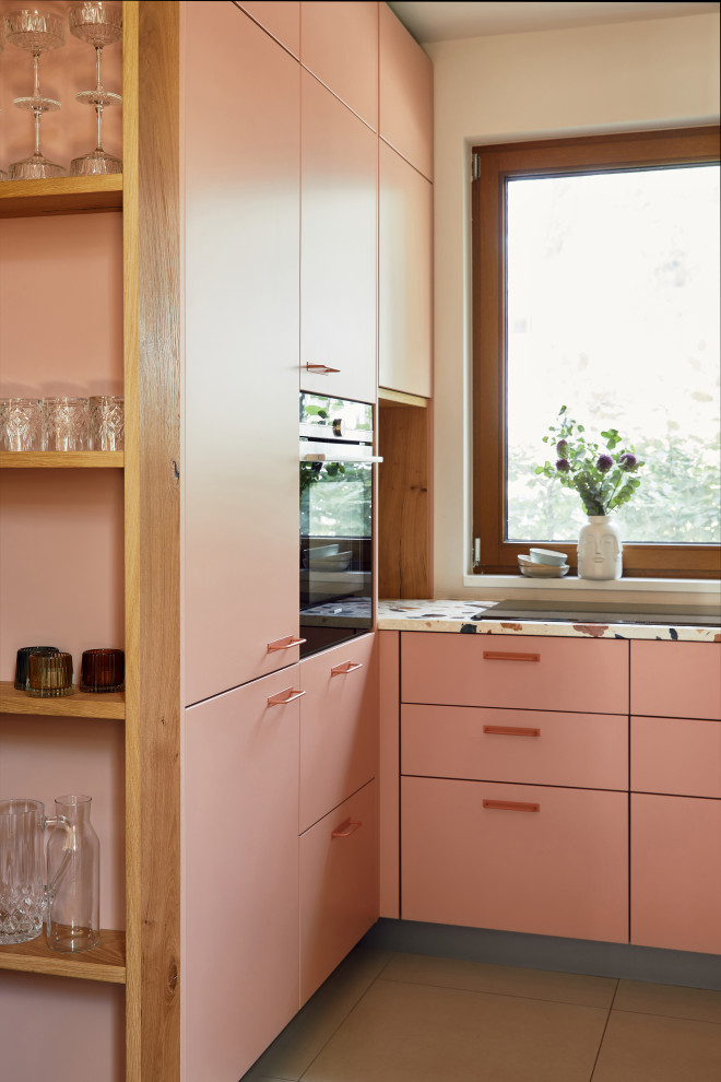 Geschlossene, Kleine Moderne Küche ohne Insel in L-Form mit pinken Schränken, Arbeitsplatte aus Terrazzo, schwarzen Elektrogeräten und bunter Arbeitsplatte in Hamburg