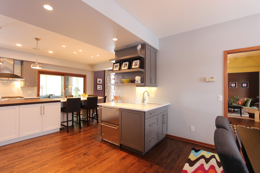 Inspiration for a large transitional medium tone wood floor great room remodel with gray walls and no fireplace