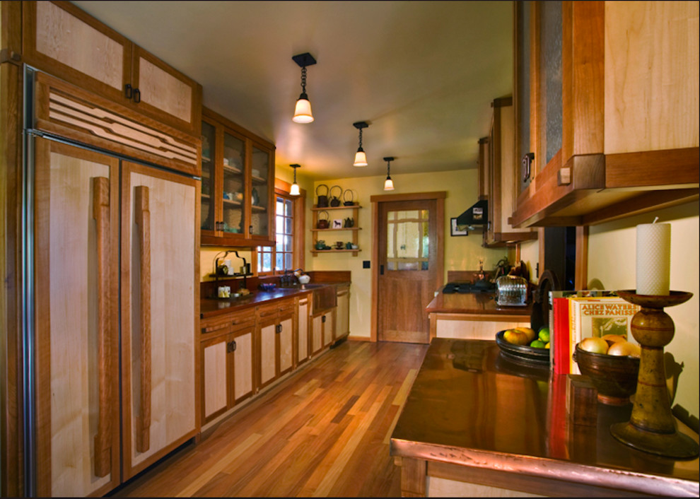 This is an example of a mid-sized asian galley separate kitchen in Santa Barbara with a farmhouse sink, flat-panel cabinets, light wood cabinets, copper benchtops, panelled appliances, medium hardwood floors and no island.