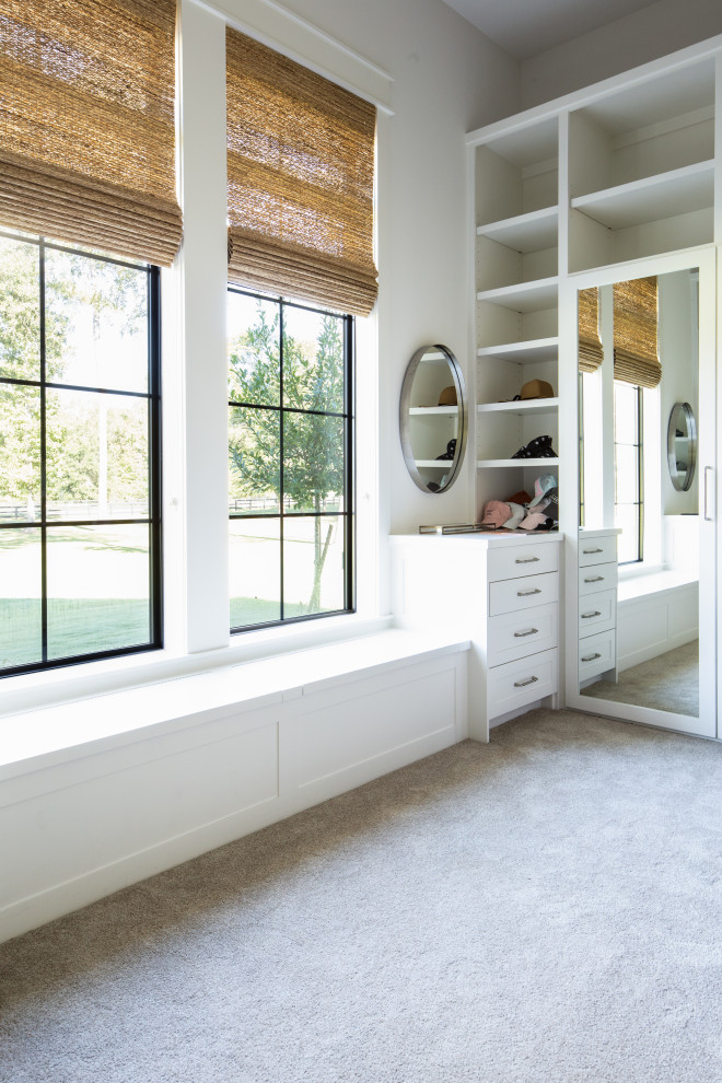 Diseño de armario vestidor campestre grande con armarios con paneles empotrados, puertas de armario blancas, moqueta y suelo beige