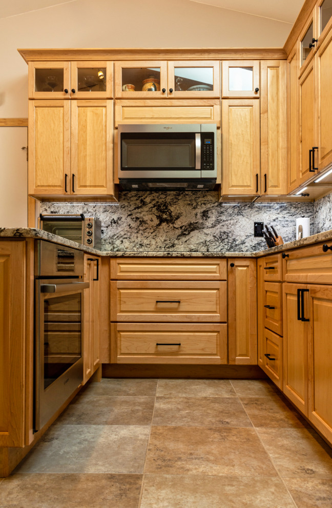 Kitchen - mid-sized traditional u-shaped porcelain tile and brown floor kitchen idea in New York with an undermount sink, raised-panel cabinets, light wood cabinets, granite countertops, white backsplash, granite backsplash, stainless steel appliances, a peninsula and white countertops