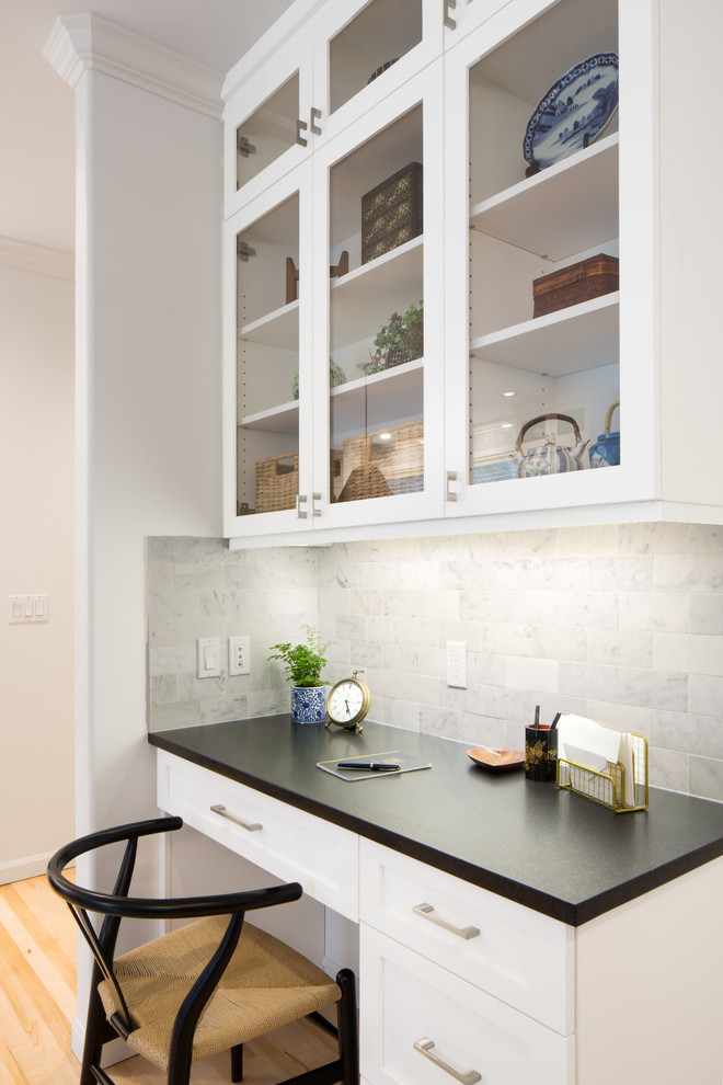 Example of a mid-sized transitional l-shaped light wood floor and brown floor eat-in kitchen design in Seattle with an undermount sink, shaker cabinets, white cabinets, quartz countertops, multicolored backsplash, marble backsplash, stainless steel appliances and an island