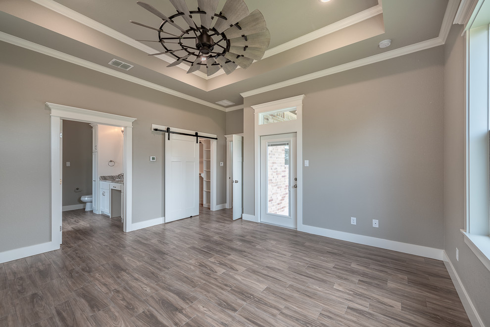 Photo of a mid-sized arts and crafts master bedroom in Other with grey walls, ceramic floors and brown floor.