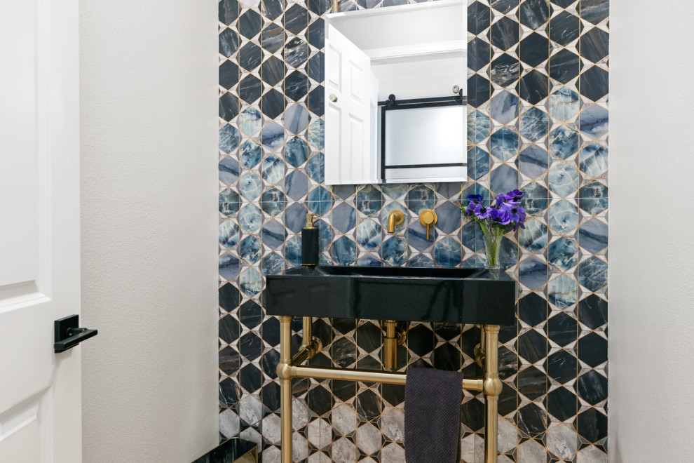 This is an example of a medium sized contemporary cloakroom in San Diego with black cabinets, a one-piece toilet, multi-coloured tiles, porcelain tiles, grey walls, porcelain flooring, an integrated sink, marble worktops, beige floors, black worktops and a freestanding vanity unit.